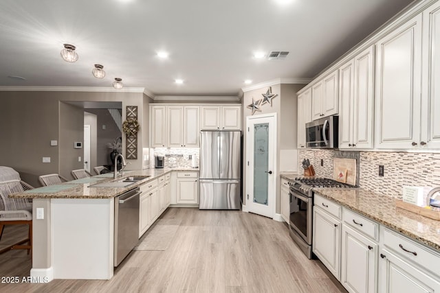 1179 E Regent Dr, Gilbert, AZ 85298 - kitchen featuring appliances with stainless steel finishes, a peninsula, crown molding, tasteful backsplash, and a sink