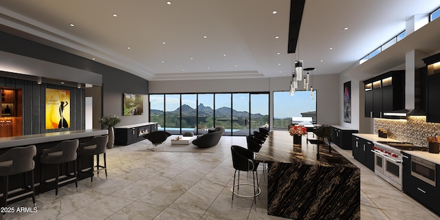 kitchen featuring a breakfast bar area, backsplash, ornamental molding, a mountain view, and range with two ovens