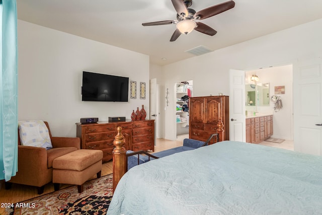 bedroom featuring connected bathroom, light hardwood / wood-style floors, and ceiling fan