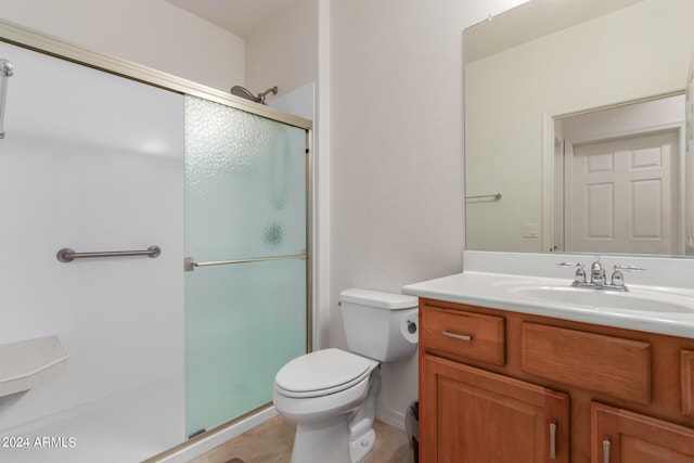 bathroom with vanity, tile patterned flooring, toilet, and walk in shower