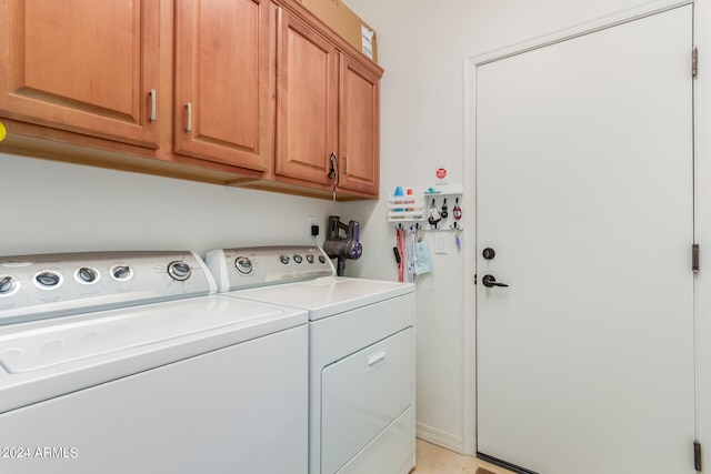 clothes washing area featuring independent washer and dryer, light tile patterned flooring, and cabinets