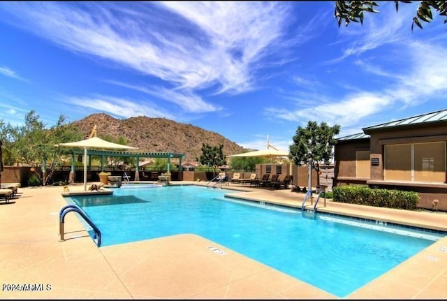 view of swimming pool with a gazebo, a mountain view, and a patio area