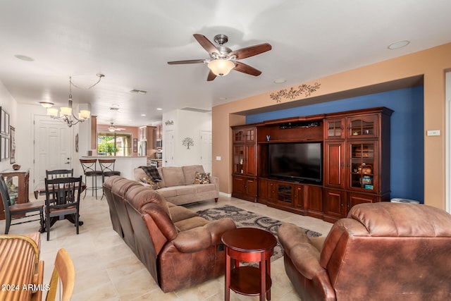 living room with ceiling fan with notable chandelier and light tile patterned floors