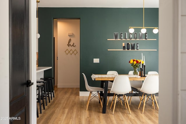 dining space featuring wood finished floors and baseboards