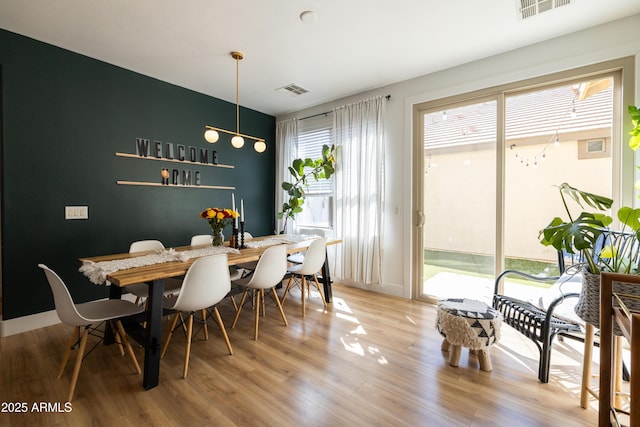 dining area featuring visible vents and wood finished floors