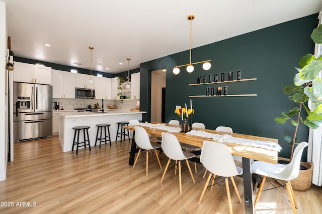 dining space featuring light wood-style flooring and recessed lighting