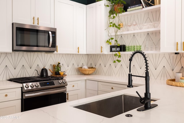 kitchen with stainless steel appliances, open shelves, and white cabinets