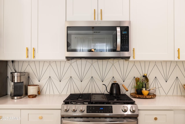 kitchen featuring white cabinetry, appliances with stainless steel finishes, light countertops, and decorative backsplash