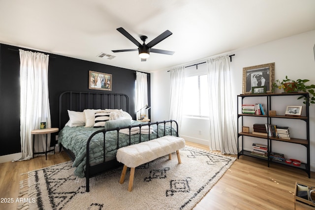 bedroom with visible vents, ceiling fan, light wood-style flooring, and baseboards