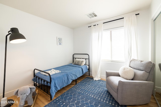 bedroom with baseboards, visible vents, and dark wood-style flooring