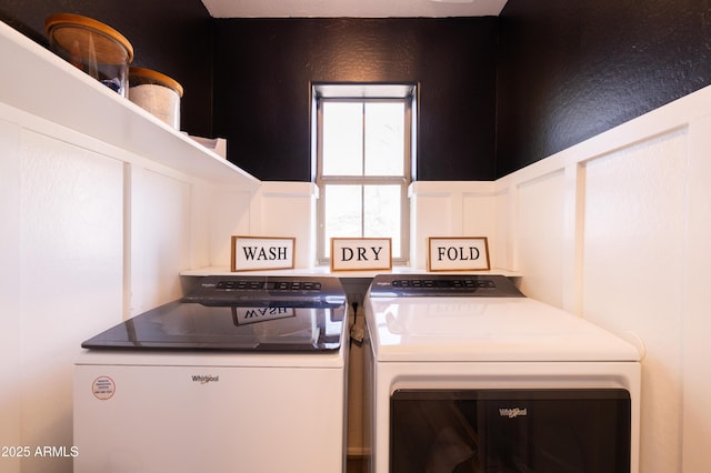 laundry room with laundry area, independent washer and dryer, and a decorative wall