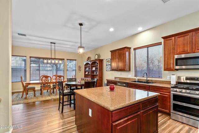 kitchen featuring light hardwood / wood-style flooring, a kitchen island, stainless steel appliances, and sink