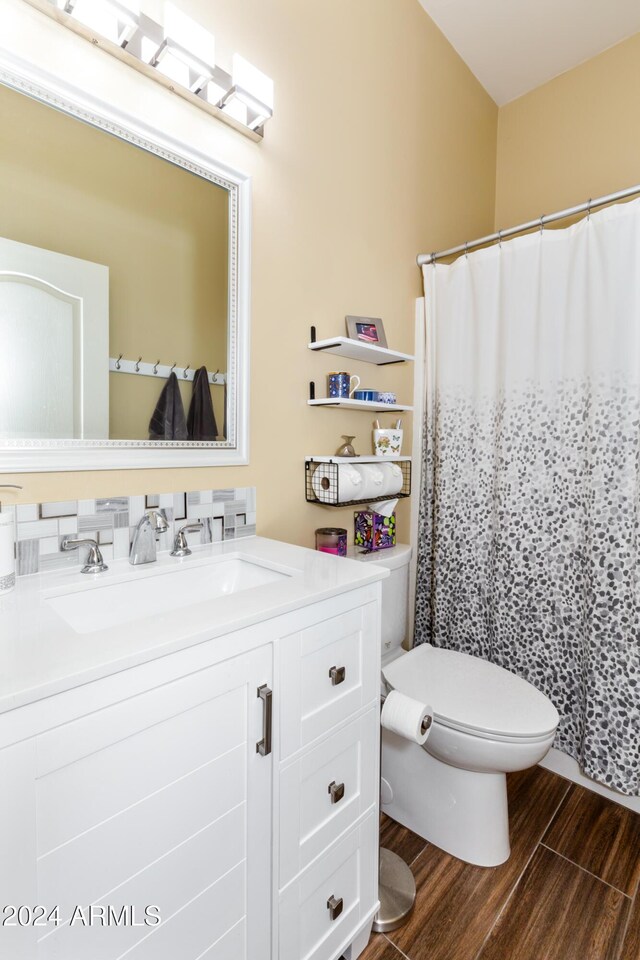 bathroom with wood-type flooring, vanity, and toilet