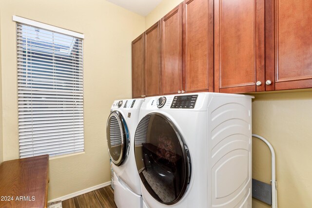 washroom with cabinets, washer and clothes dryer, and dark wood-type flooring