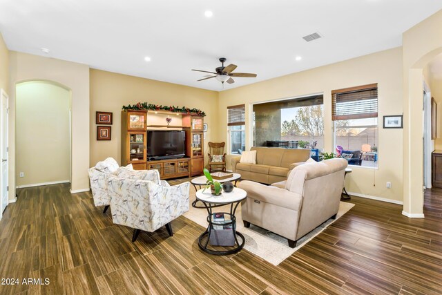 living room with dark hardwood / wood-style flooring and ceiling fan