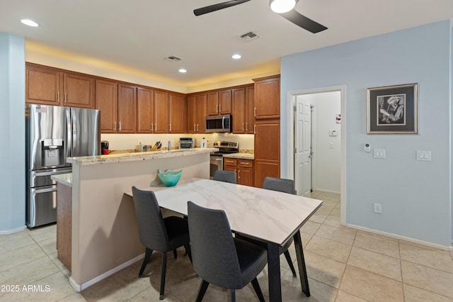 kitchen with appliances with stainless steel finishes, visible vents, ceiling fan, and light tile patterned flooring