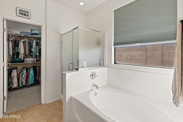 bathroom with tile patterned flooring, recessed lighting, a shower stall, a bath, and a walk in closet