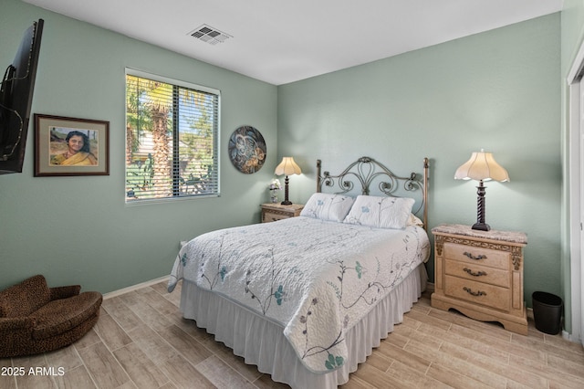 bedroom featuring wood tiled floor, visible vents, and baseboards