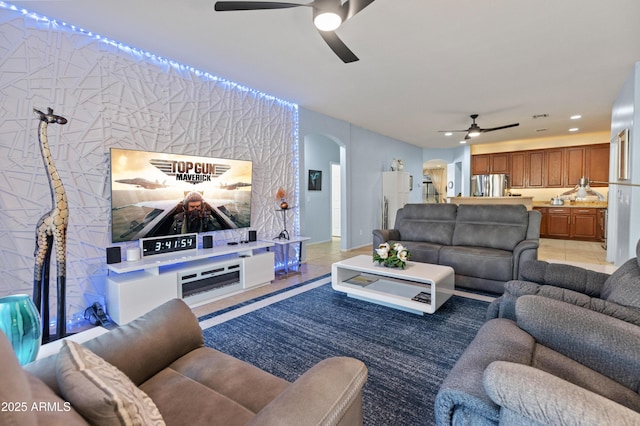 living room featuring arched walkways, ceiling fan, light tile patterned floors, and recessed lighting