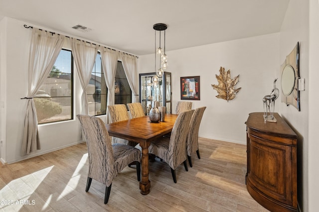 dining area featuring light wood-style floors and visible vents