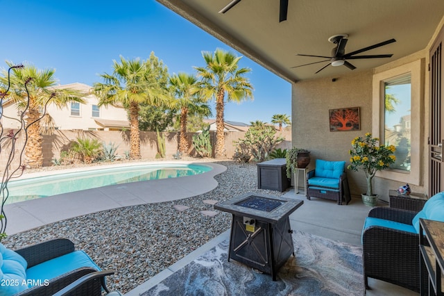 view of patio / terrace with a fenced in pool, a fenced backyard, a fire pit, and a ceiling fan