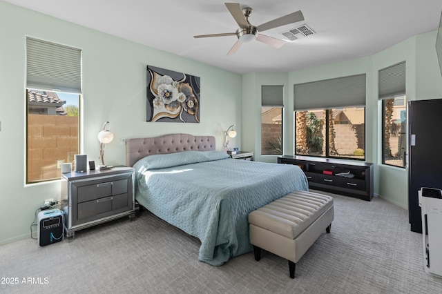 carpeted bedroom featuring a ceiling fan, visible vents, and baseboards