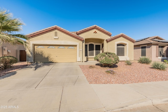 mediterranean / spanish-style home with a garage, a tile roof, concrete driveway, and stucco siding