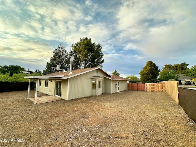 rear view of property with a fenced backyard, central AC unit, and a patio area