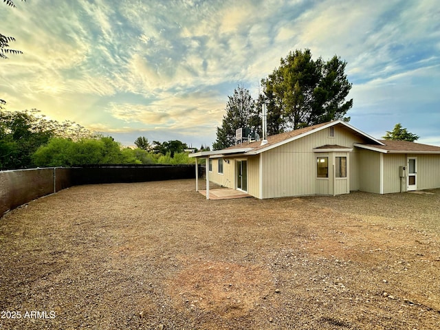 rear view of house with a patio area and fence
