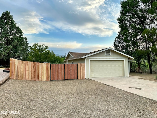 garage with fence and driveway