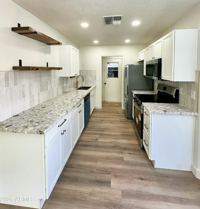 kitchen with a sink, white cabinets, stainless steel appliances, and visible vents