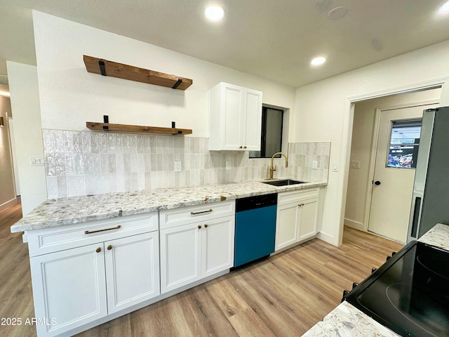 kitchen featuring open shelves, a sink, light wood-style floors, freestanding refrigerator, and dishwashing machine