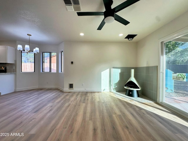 unfurnished living room with visible vents, light wood finished floors, and a healthy amount of sunlight