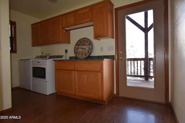 kitchen with brown cabinetry, visible vents, dark wood-type flooring, washer and dryer, and dark countertops