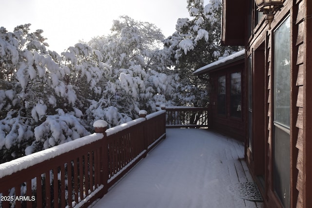 view of snow covered back of property