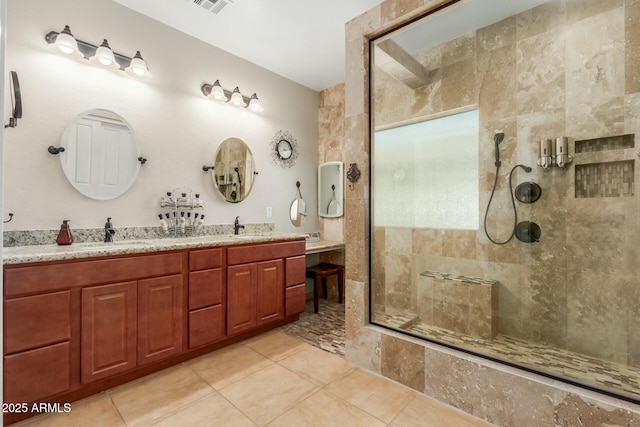 bathroom featuring tiled shower, vanity, and tile patterned floors