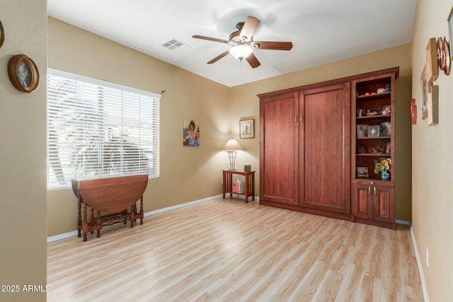 sitting room with a healthy amount of sunlight, ceiling fan, and light hardwood / wood-style floors