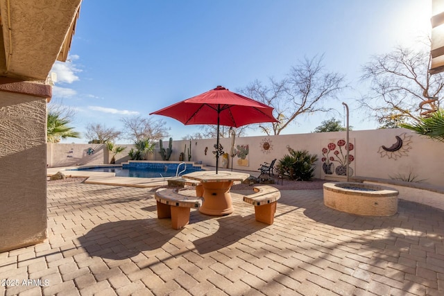 view of patio / terrace with pool water feature, a fenced in pool, and an outdoor fire pit