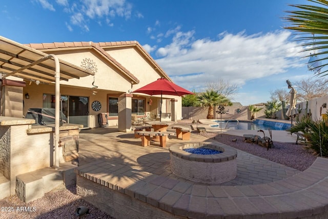 view of patio / terrace featuring a fenced in pool, exterior bar, area for grilling, a grill, and an outdoor fire pit