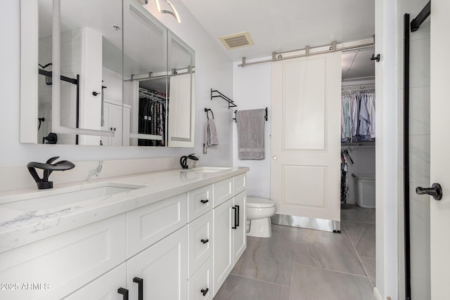 1 E Lexington Ave Unit 1108, Phoenix, AZ 85012 - full bathroom featuring a walk in closet, double vanity, toilet, and marble look tiles