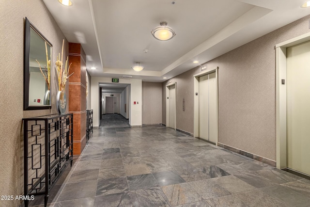 1 E Lexington Ave Unit 1108, Phoenix, AZ 85012 - hallway with elevator, a tray ceiling, stone finish floors, and recessed lighting
