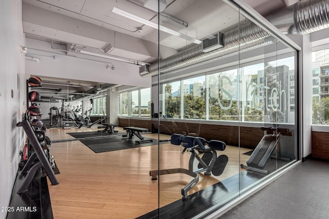 1 E Lexington Ave Unit 1108, Phoenix, AZ 85012 - workout area featuring healthy amount of natural light, brick wall, and wood finished floors