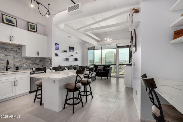 1 E Lexington Ave Unit 1108, Phoenix, AZ 85012 - kitchen with a sink, decorative backsplash, a kitchen breakfast bar, a high ceiling, and open floor plan