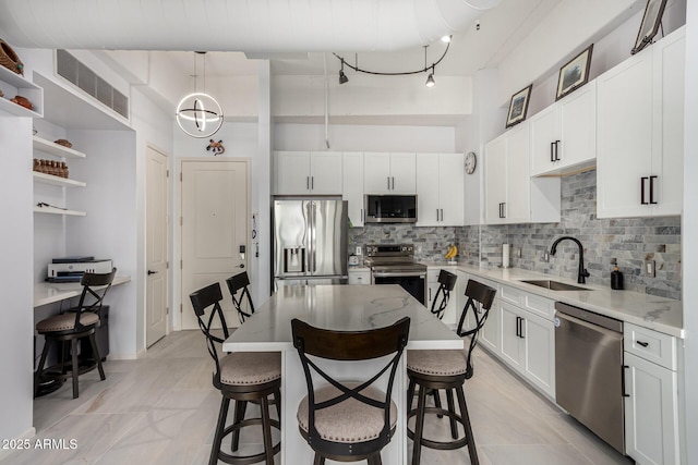 1 E Lexington Ave Unit 1108, Phoenix, AZ 85012 - kitchen featuring appliances with stainless steel finishes, a sink, open shelves, a breakfast bar, and backsplash