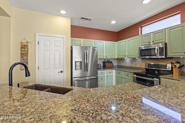 kitchen with dark stone countertops, green cabinetry, and stainless steel appliances