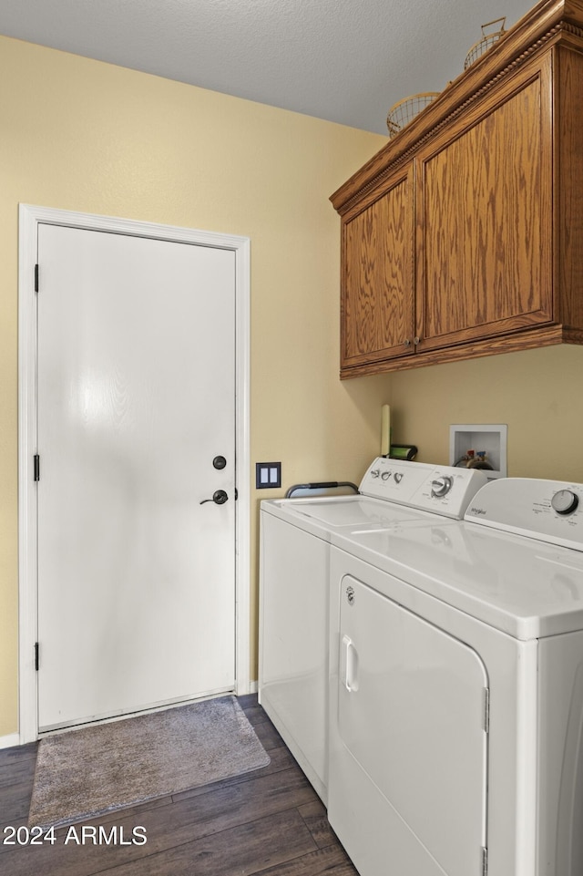 washroom featuring dark wood-type flooring, independent washer and dryer, cabinets, and a textured ceiling