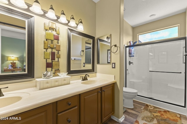 bathroom with an enclosed shower, wood-type flooring, vanity, and toilet