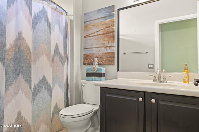 bathroom featuring a shower with shower curtain, vanity, and toilet