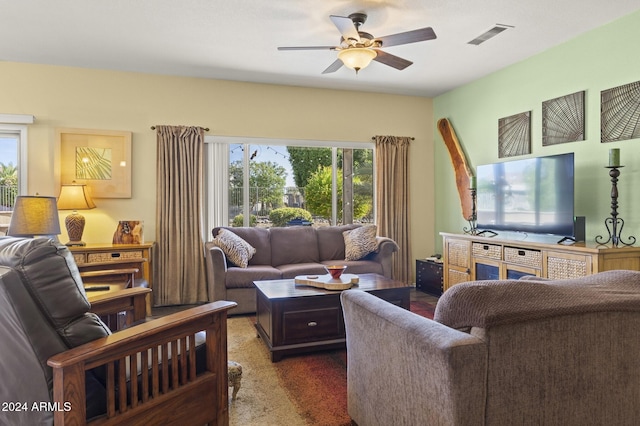 living room featuring ceiling fan and dark colored carpet