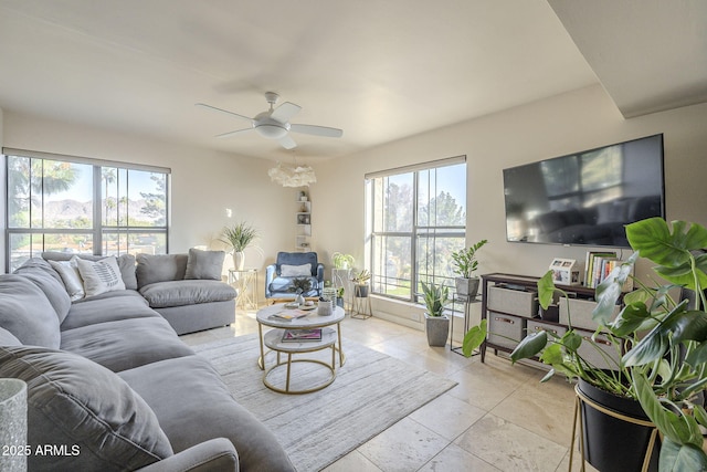 living room with a wealth of natural light, ceiling fan, and light tile patterned flooring